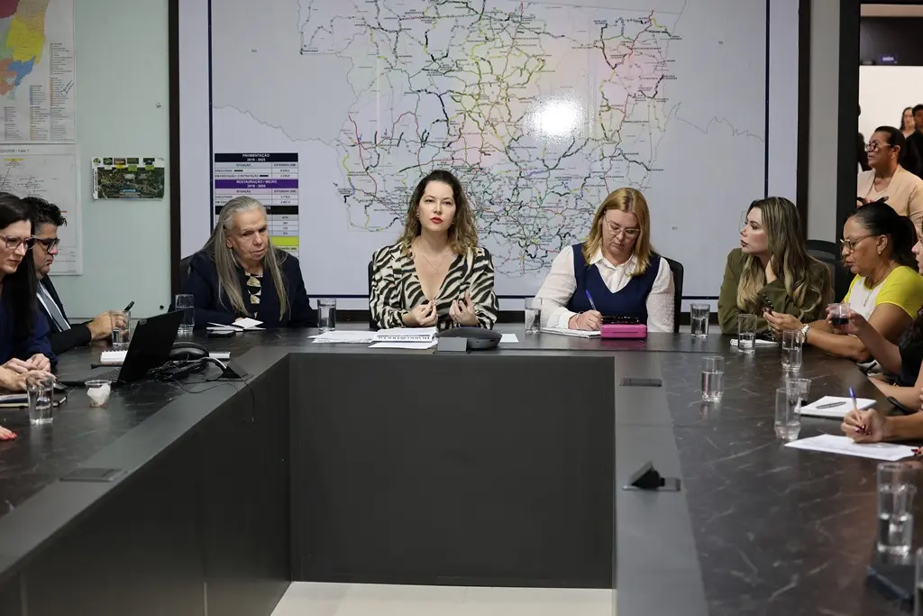Foto horizontal colorida, em plano aberto, que mostra a cabeceira de uma mesa de reunião, composta por diversas autoridades do Estado, entre elas a desembargadora Maria Erotides Kneip e a secretária-chefe do Gabinete de Enfrentamento à Violência Contra a Mulher, Mariell Antonini.