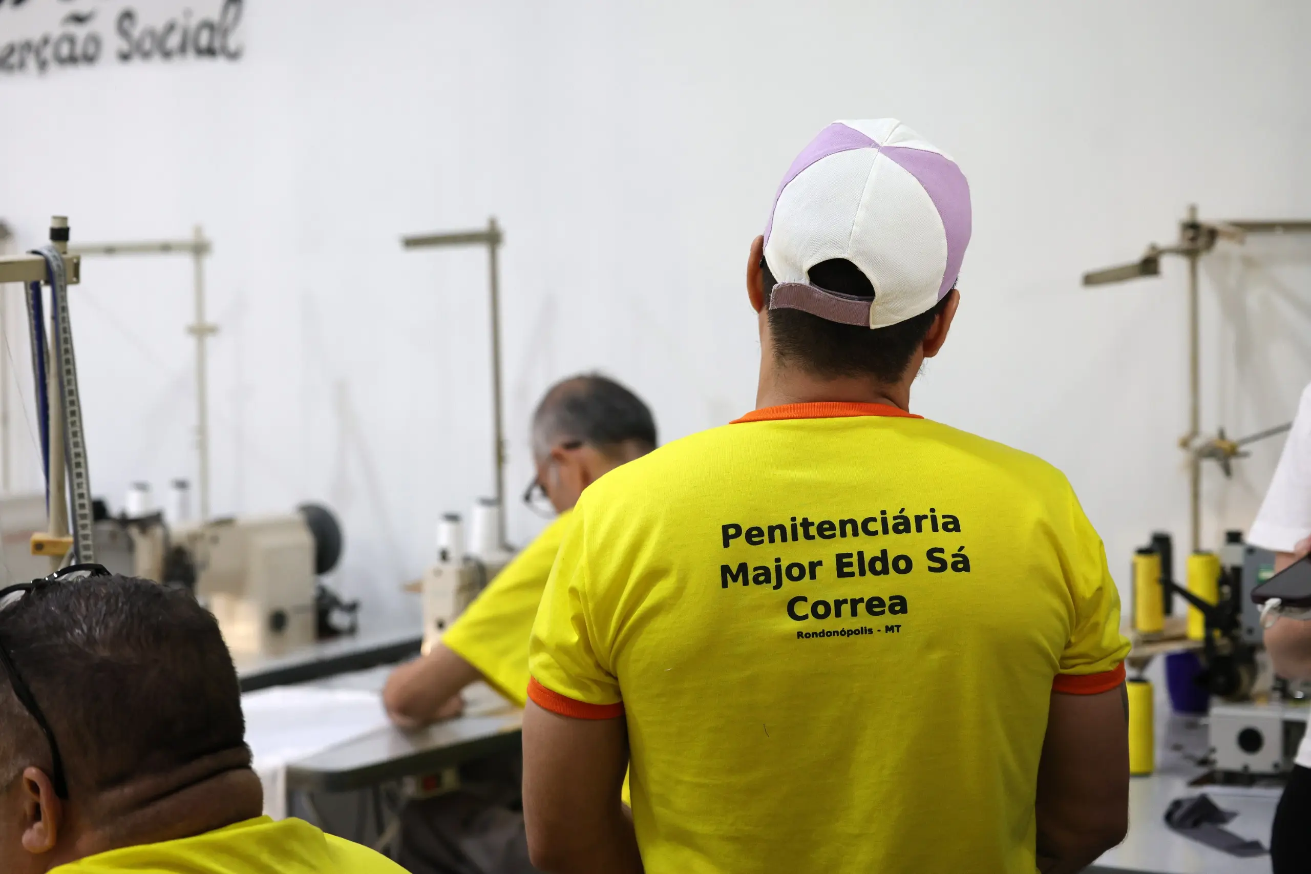 Homem de costas veste camiseta amarela com a inscrição
